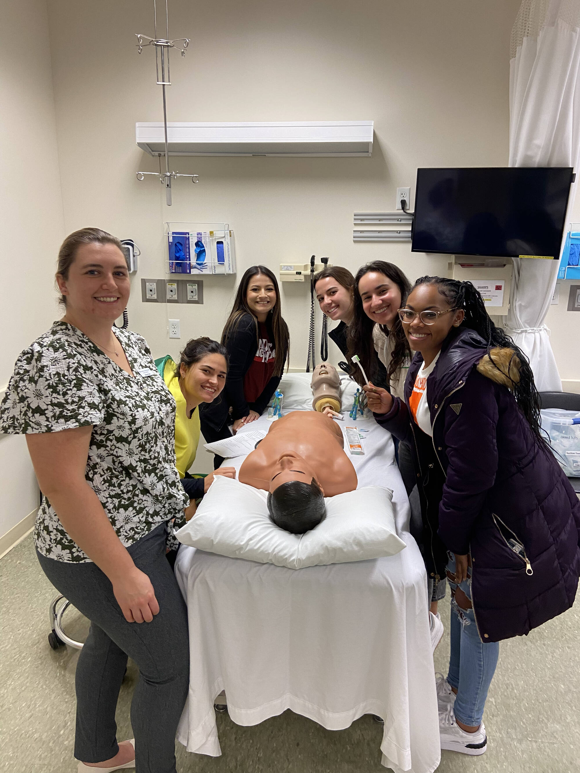 Students posing with a manikin